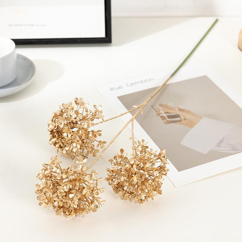 Trang trí đám cưới giả màu vàng: lá eucalyptus, hoa giả, cành giả, chi tiết vàng cho trang trí lối đi.