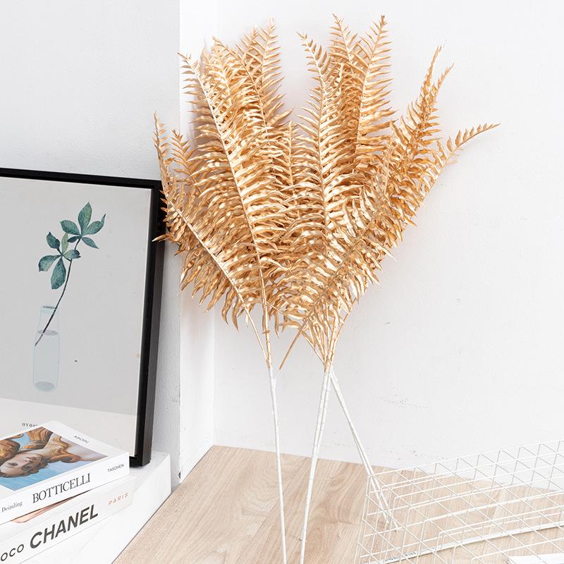 Trang trí đám cưới giả màu vàng: lá eucalyptus, hoa giả, cành giả, chi tiết vàng cho trang trí lối đi.