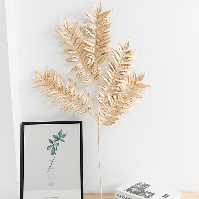 Trang trí đám cưới giả màu vàng: lá eucalyptus, hoa giả, cành giả, chi tiết vàng cho trang trí lối đi.